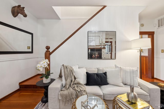 living area featuring wainscoting, a skylight, and wood finished floors