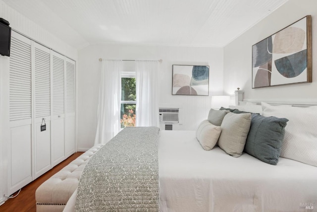 bedroom featuring a wall mounted AC, dark wood-type flooring, and a closet