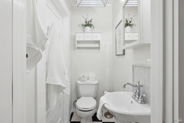 half bath featuring toilet and a sink