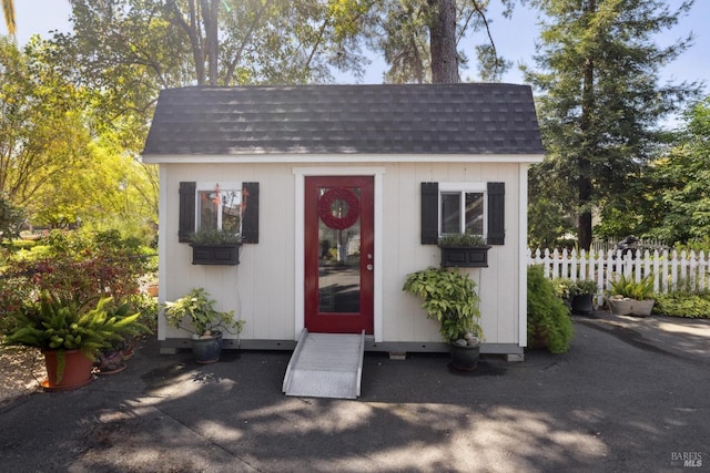 view of outbuilding featuring an outbuilding and fence