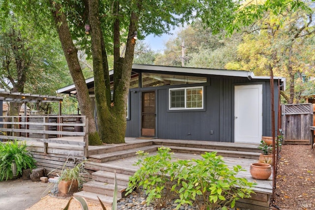 view of front facade featuring a wooden deck and fence