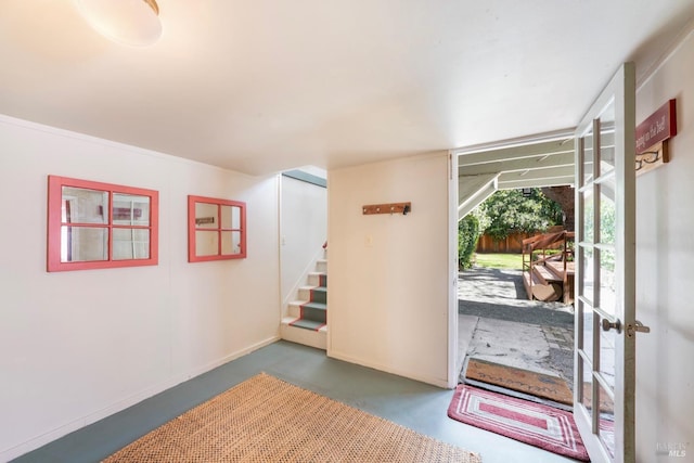 interior space with baseboards, stairs, and finished concrete floors