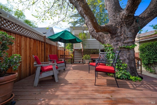 wooden terrace featuring fence and stairway