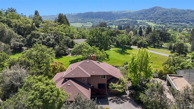 birds eye view of property featuring a view of trees and a mountain view