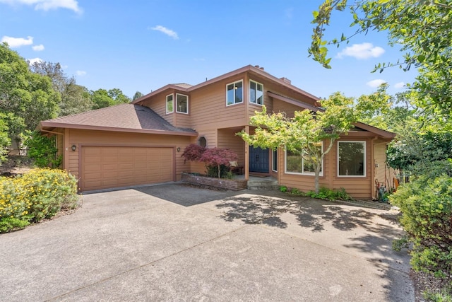 view of front of home featuring an attached garage, a shingled roof, and concrete driveway