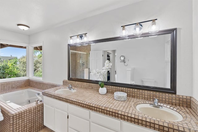 bathroom with a garden tub, a sink, a shower stall, and double vanity