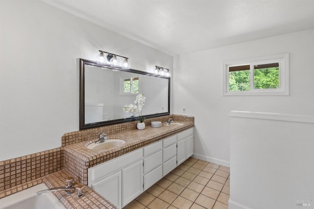 bathroom with baseboards, tile patterned floors, a sink, and double vanity