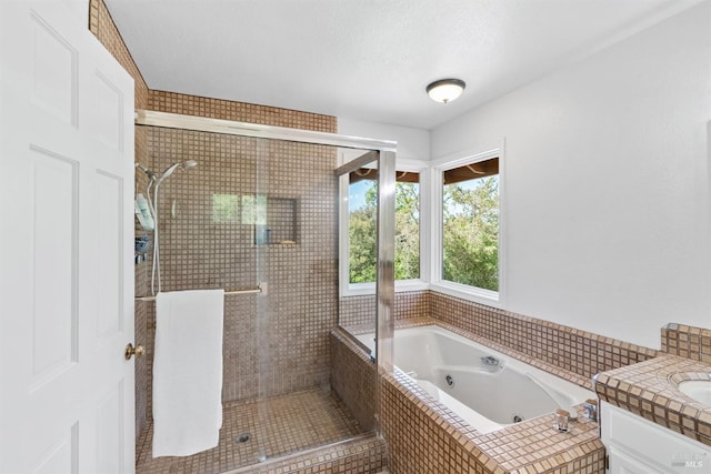 bathroom with vanity, a shower stall, and a tub with jets