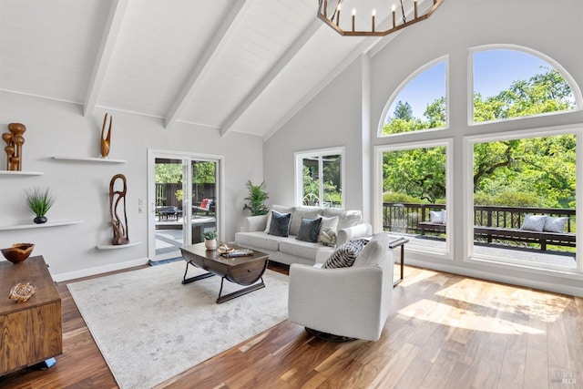 living room with baseboards, a chandelier, beamed ceiling, wood finished floors, and high vaulted ceiling
