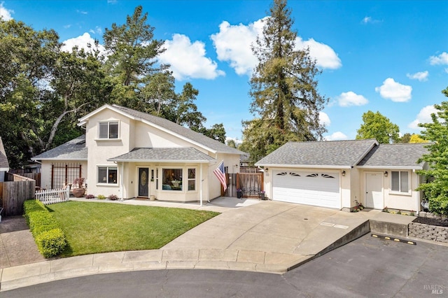 view of front of house featuring driveway, fence, a front yard, a garage, and stucco siding