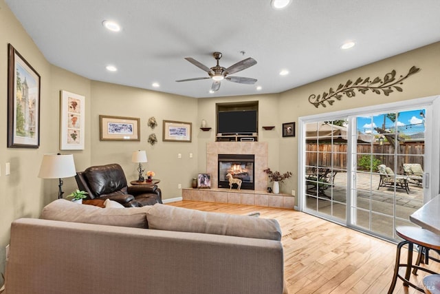 living room with a tile fireplace, ceiling fan, wood finished floors, and recessed lighting