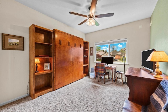 office space with a ceiling fan, baseboards, and carpet