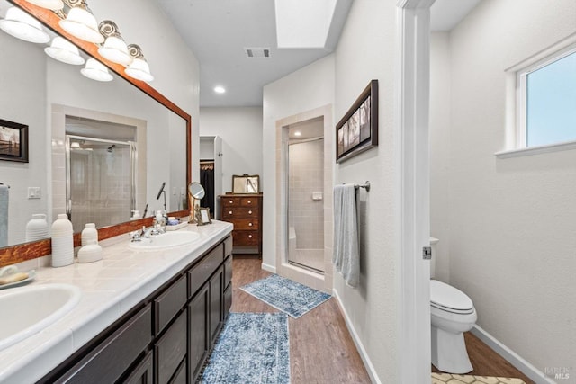 full bathroom with a shower stall, toilet, wood finished floors, and a sink