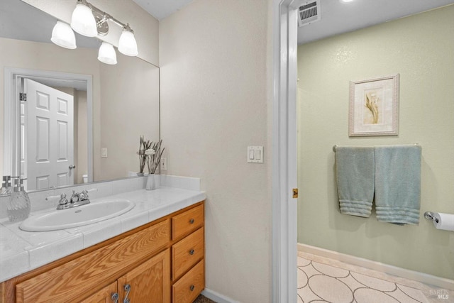bathroom featuring baseboards, vanity, and visible vents