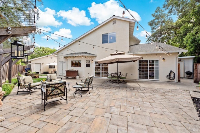 back of property with outdoor lounge area, a shingled roof, fence, a patio, and stucco siding