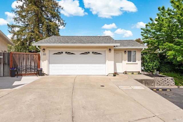 single story home with a garage, driveway, stucco siding, and fence