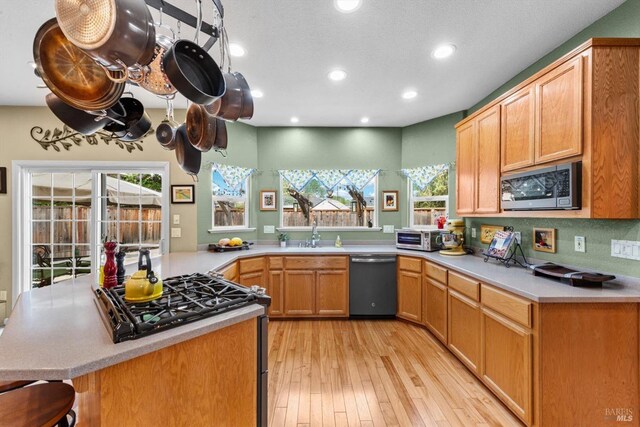kitchen with plenty of natural light, light wood-style floors, stainless steel appliances, and recessed lighting