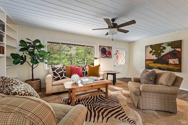 living room with wood ceiling, ceiling fan, and baseboards