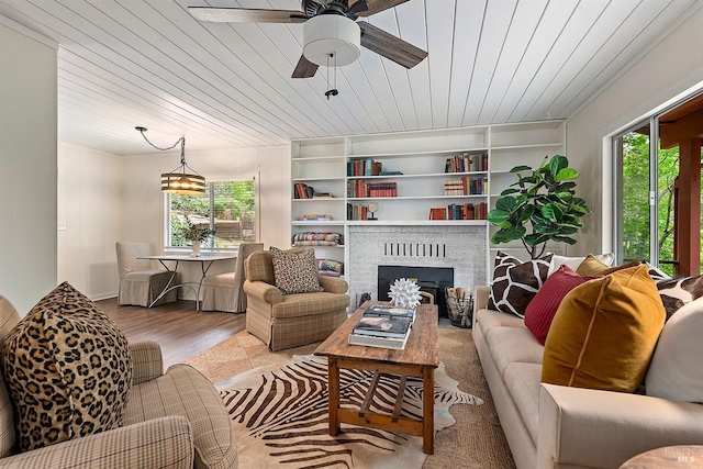 living area featuring a ceiling fan, wooden ceiling, wood finished floors, and plenty of natural light