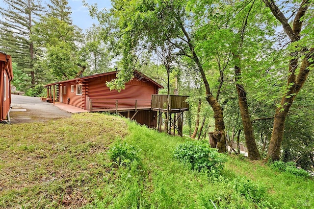 view of property exterior with a deck and log exterior