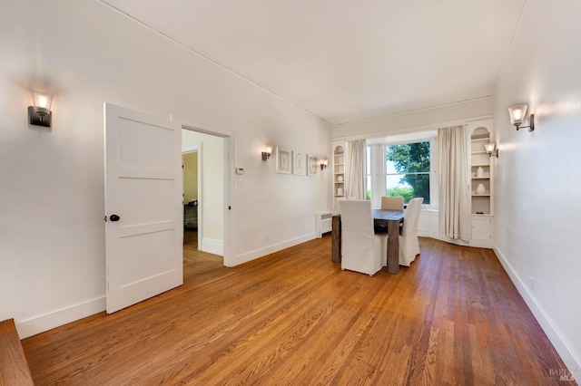 unfurnished dining area featuring wood finished floors and baseboards
