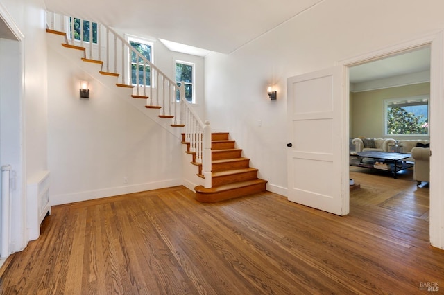 stairs with wood finished floors and baseboards