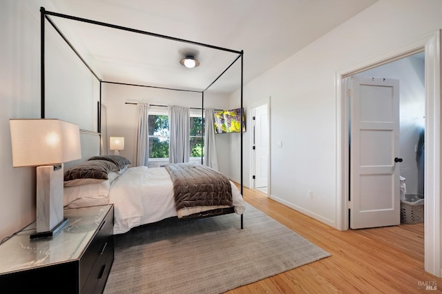 bedroom with light wood-style flooring and baseboards