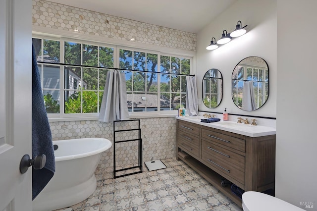 bathroom with a soaking tub and vanity