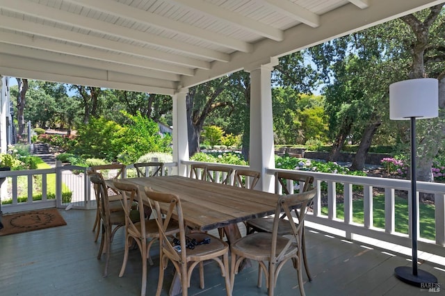exterior space with a wooden deck and outdoor dining area