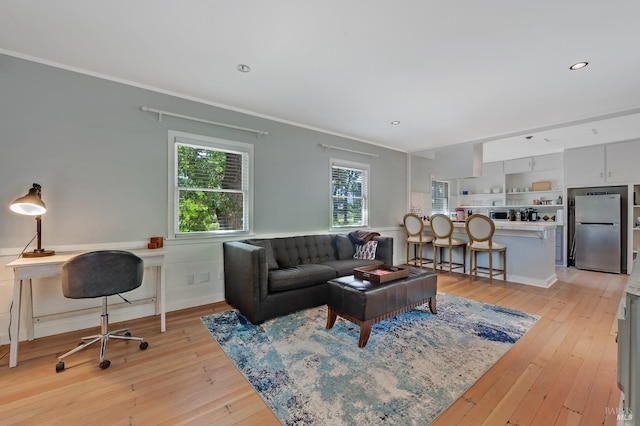 living room with crown molding, a wainscoted wall, light wood finished floors, and recessed lighting