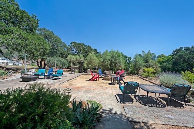 exterior space featuring an outdoor living space with a fire pit and a patio