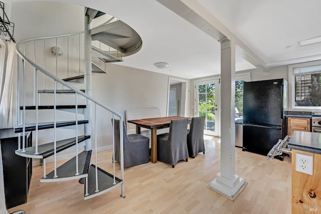 dining space with light wood-style floors and stairway