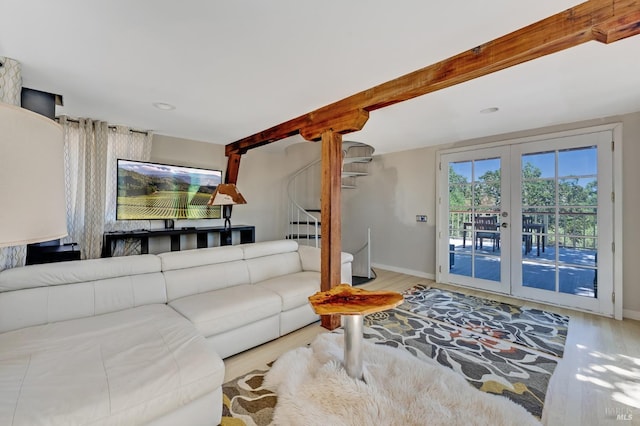 living area with french doors, baseboards, beamed ceiling, wood finished floors, and stairs