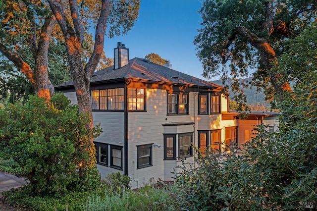back of property with a chimney