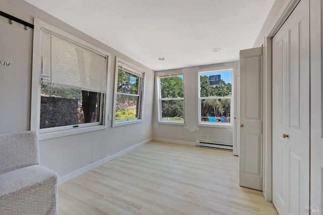 unfurnished sunroom featuring baseboard heating and plenty of natural light