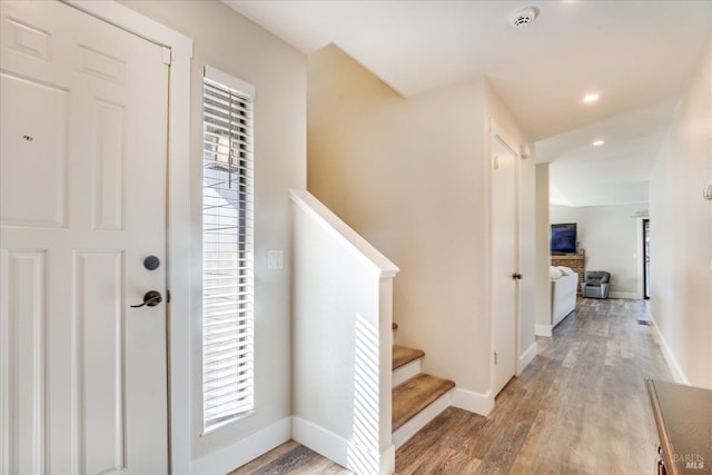 entryway with stairway, baseboards, a healthy amount of sunlight, and wood finished floors