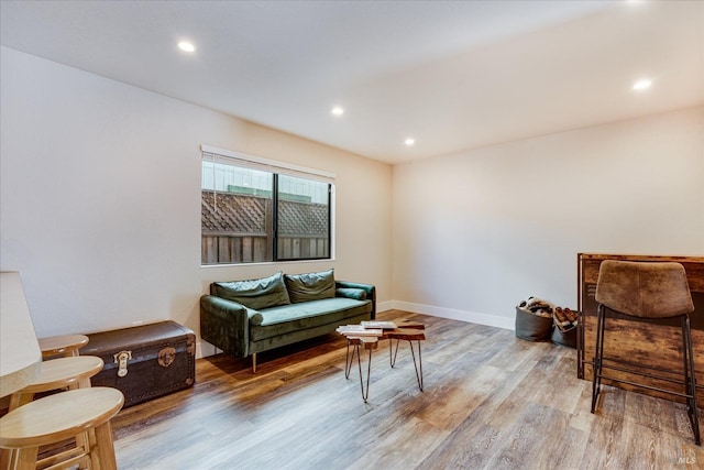 living area featuring baseboards, recessed lighting, and light wood-style floors