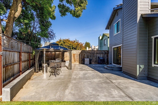 view of patio / terrace with outdoor dining area, a gazebo, and a fenced backyard
