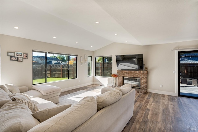 living area with baseboards, recessed lighting, lofted ceiling, wood finished floors, and a fireplace