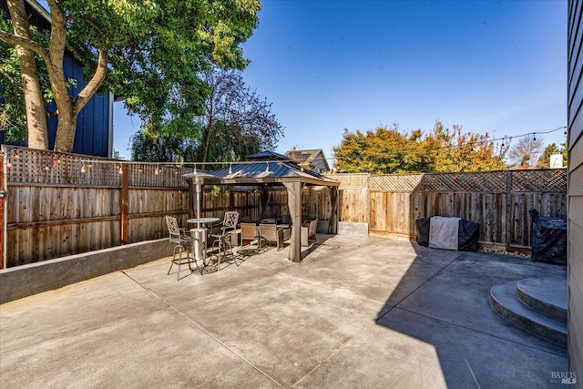 view of patio with a gazebo, a fenced backyard, and outdoor dining area
