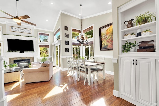 470 Camellia Ct, Benicia, CA 94510 - living room with light wood-type flooring, ceiling fan with notable chandelier, crown molding, and a glass covered fireplace