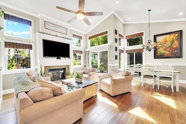 470 Camellia Ct, Benicia, CA 94510 - living area featuring hardwood / wood-style flooring, baseboards, a glass covered fireplace, high vaulted ceiling, and ceiling fan with notable chandelier