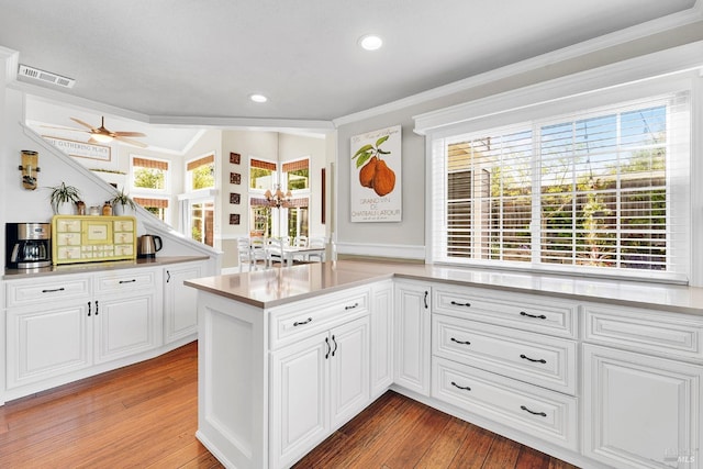 470 Camellia Ct, Benicia, CA 94510 - kitchen featuring light wood-style flooring, white cabinets, visible vents, light countertops, and ornamental molding