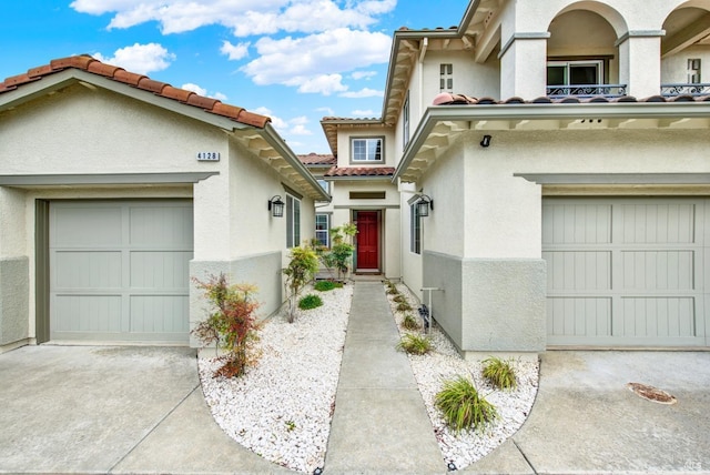 mediterranean / spanish home with concrete driveway, a tiled roof, and stucco siding