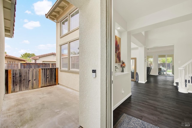 view of side of home featuring stucco siding and fence