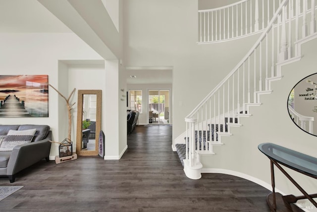 foyer featuring baseboards, a high ceiling, stairs, and dark wood finished floors