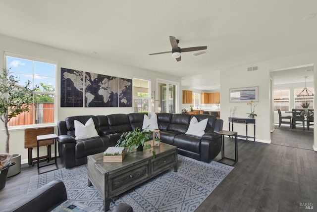 living area with baseboards, visible vents, dark wood-style floors, and ceiling fan