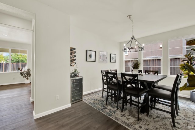 dining area featuring dark wood-type flooring, baseboards, and a notable chandelier