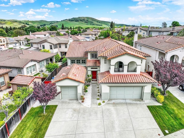 view of front of property with a residential view, a tile roof, driveway, fence, and stucco siding