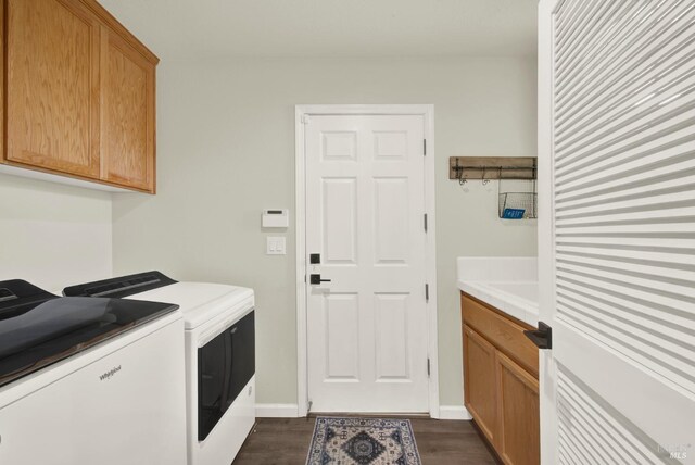 laundry room with washer and dryer, baseboards, cabinet space, and dark wood-type flooring